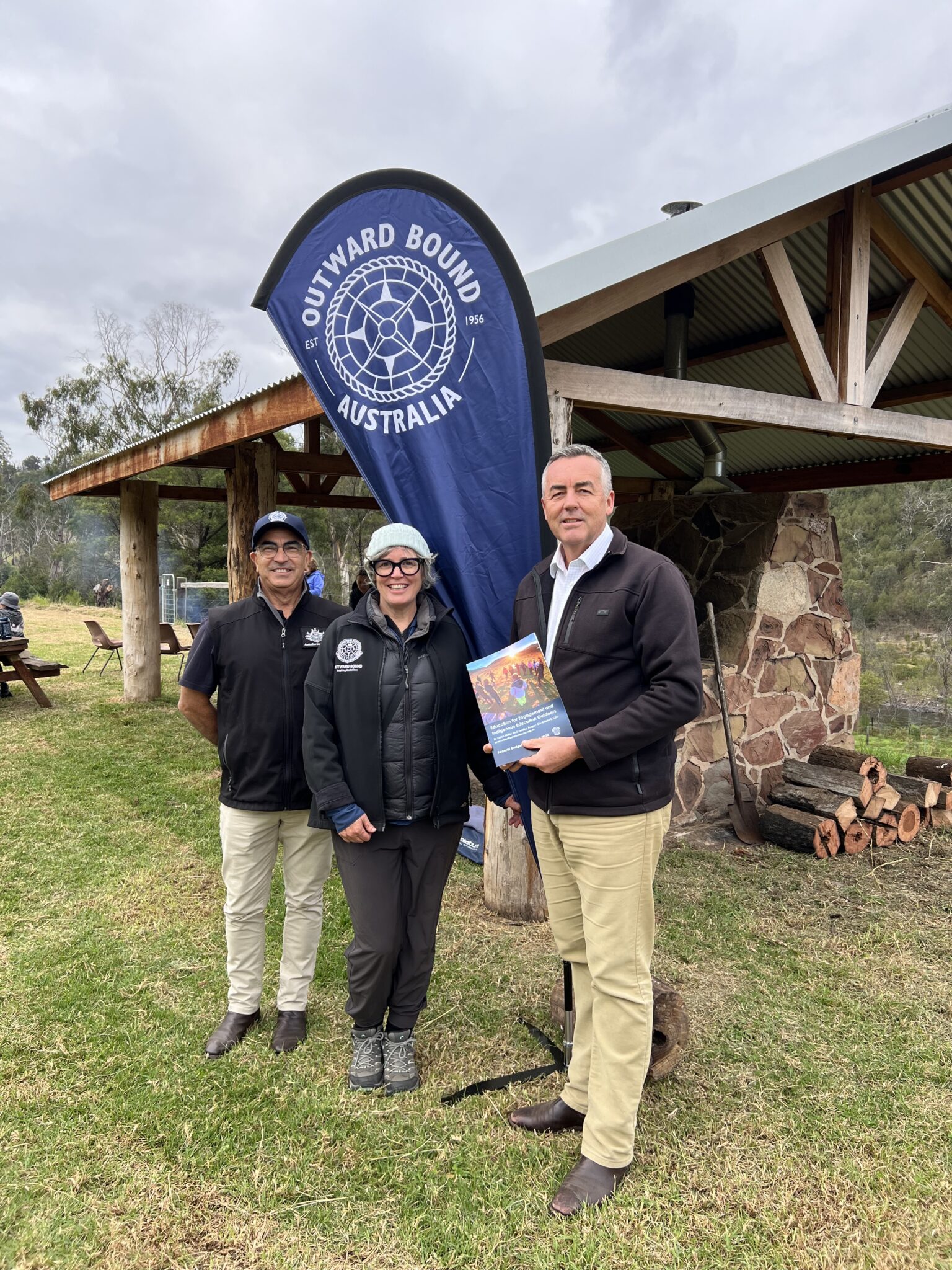National Emergency Management Australia's Gippsland Coordination Planning Officer Joe Rettino, Outward Bound co-chair Dr Loren Miller and Federal Member for Gippsland Darren Chester at one of the new shelters which was built following the Black Summer bushfires.